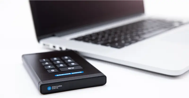 An image of a SecureDrive® KP encrypted drive connected to a laptop.