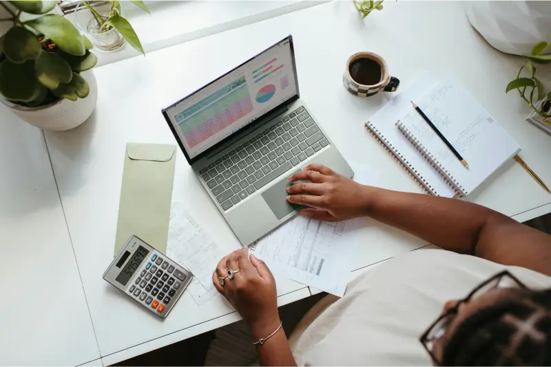 Person sitting at a table with a laptop displaying business information